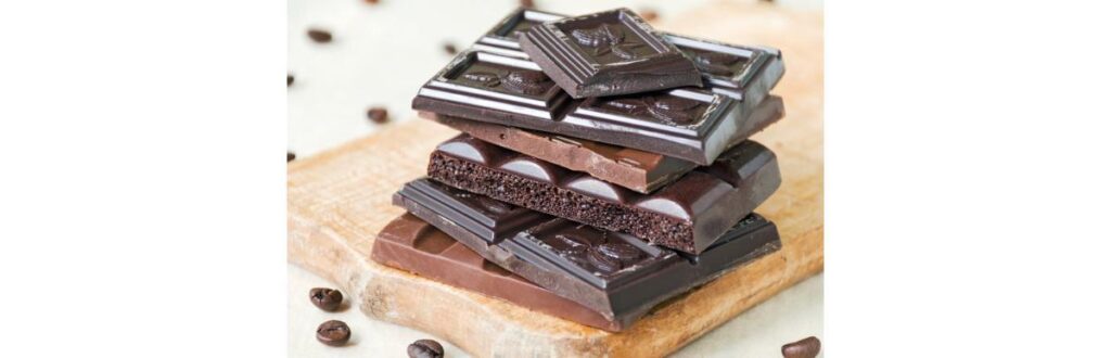 broken-chocolate-bars-of-different-kinds-of-chocolate-are-stacked-on-picture-id833999078