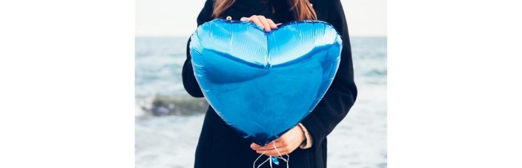 girl-in-black-coat-holding-a-blue-balloon-picture-id519712040