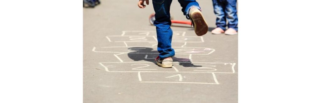 kids-playing-hopscotch-on-playground-outdoors-picture-id512047790