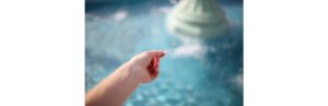 womans-hand-throwing-coin-in-wishing-fountain-picture-id809056542