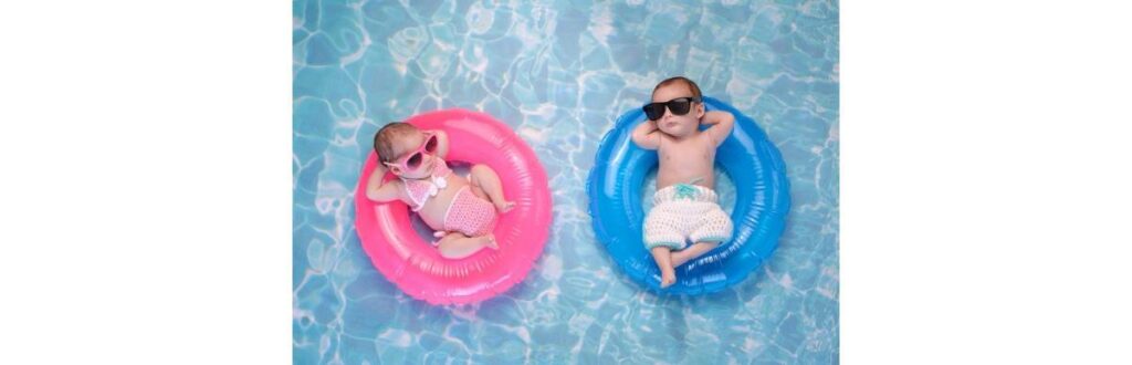 baby-twin-boy-and-girl-floating-on-swim-rings-picture-id628951466