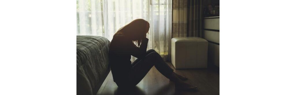 depressed-woman-sitting-in-the-dark-bedroom-picture-id680834894