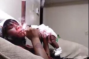 Ela fumou perto do rosto do bebê e levantou a criança várias vezes apenas com um braço