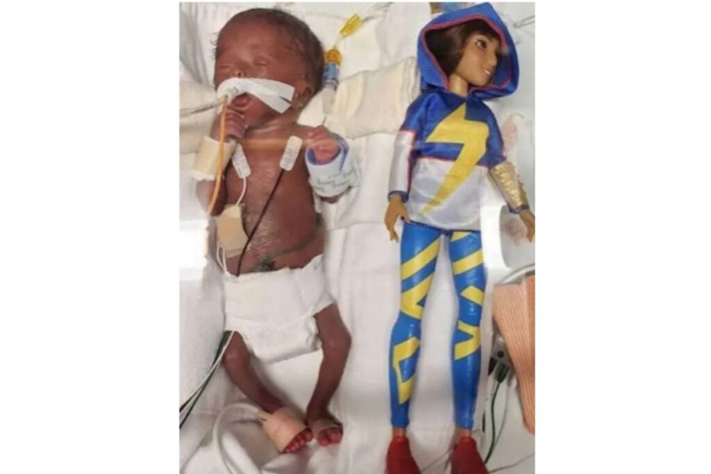 A menina é tão pequena que a mãe consegue pegar o punho dela entre os dedos