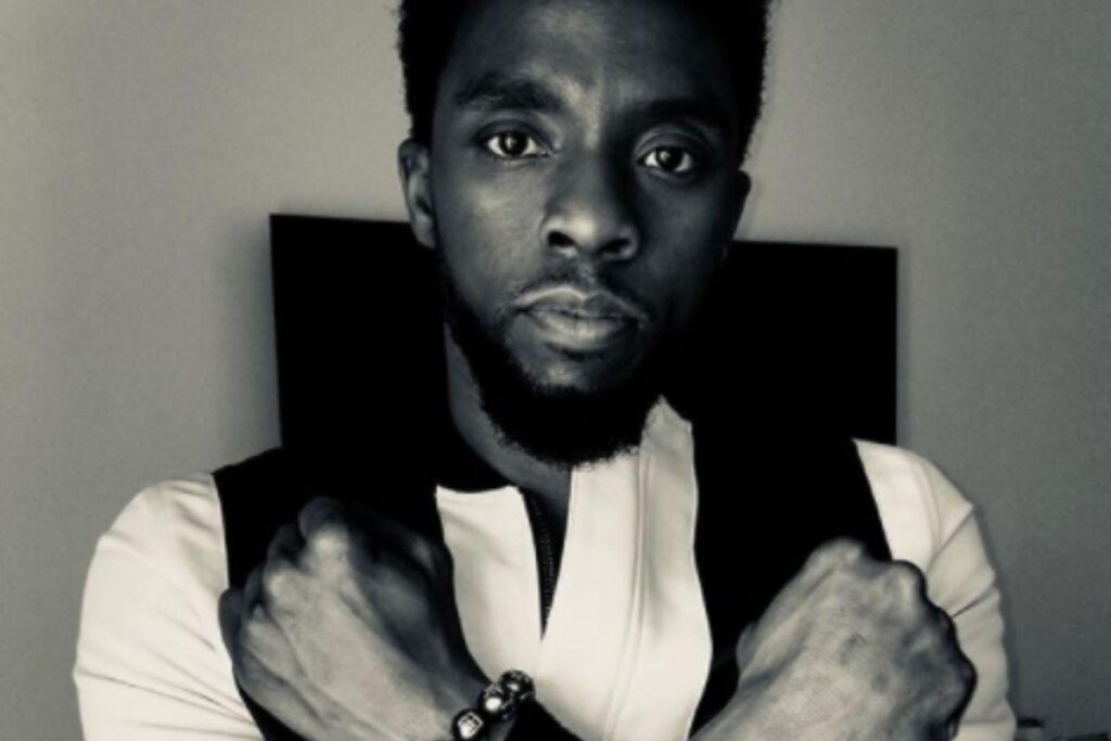 O artista, Nikkolas ao lado do mural em homenagem ao Chadwick