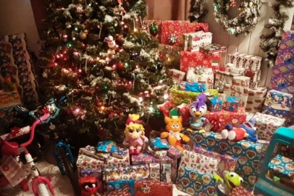 As crianças ganham uma pilha de presente dos pais