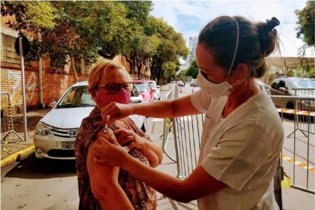 Menino que levou cartaz agradecendo pela vacinação da avó