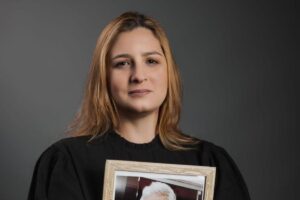 Ela fez uma foto segurando o retrato do pai