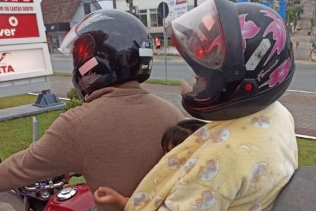 A criança estava no meio de duas pessoas na moto