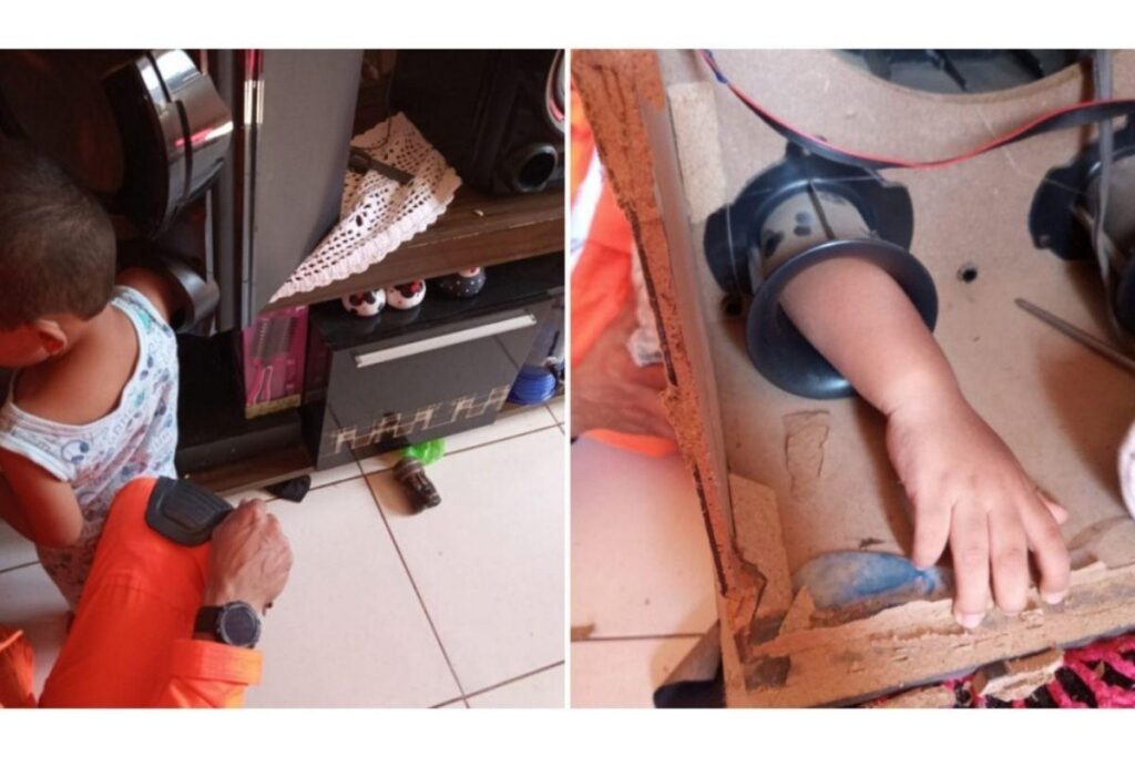 Menino com o braço dentro da caixa de som desmontada