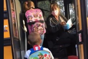 A motorista está distribuindo máscaras para as crianças enquanto discute com a mãe