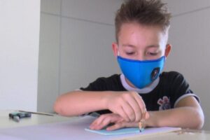 Menino faz máscaras para doar aos colegas