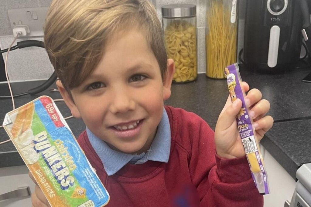 Cena do menino ralando queijo direto na boca