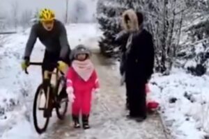 Registro do ciclista empurrando a criança