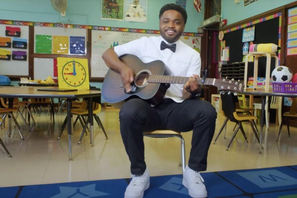 Professor canta música para crianças no primeiro dia de aula do jardim da infância