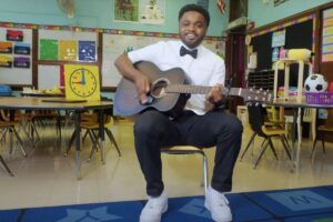 Professor canta música para crianças no primeiro dia de aula do jardim da infância