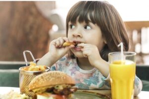 Mulher alimneta filha da amiga dela que é vegana com carne