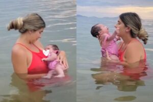 Mãe amamenta filha no mar