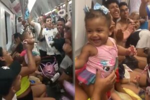 Momento em que os foliões cantavam para a bebê no vagão do metrô