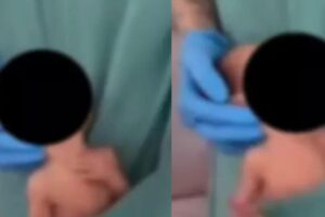 Fisioterapeuta dança com bebê recém-nascido no bolso de seu uniforme