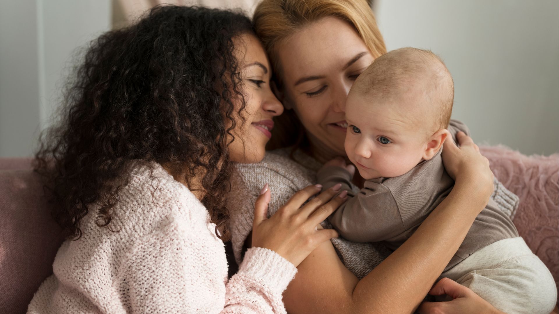 duas m&atilde;es segurando um beb&ecirc;