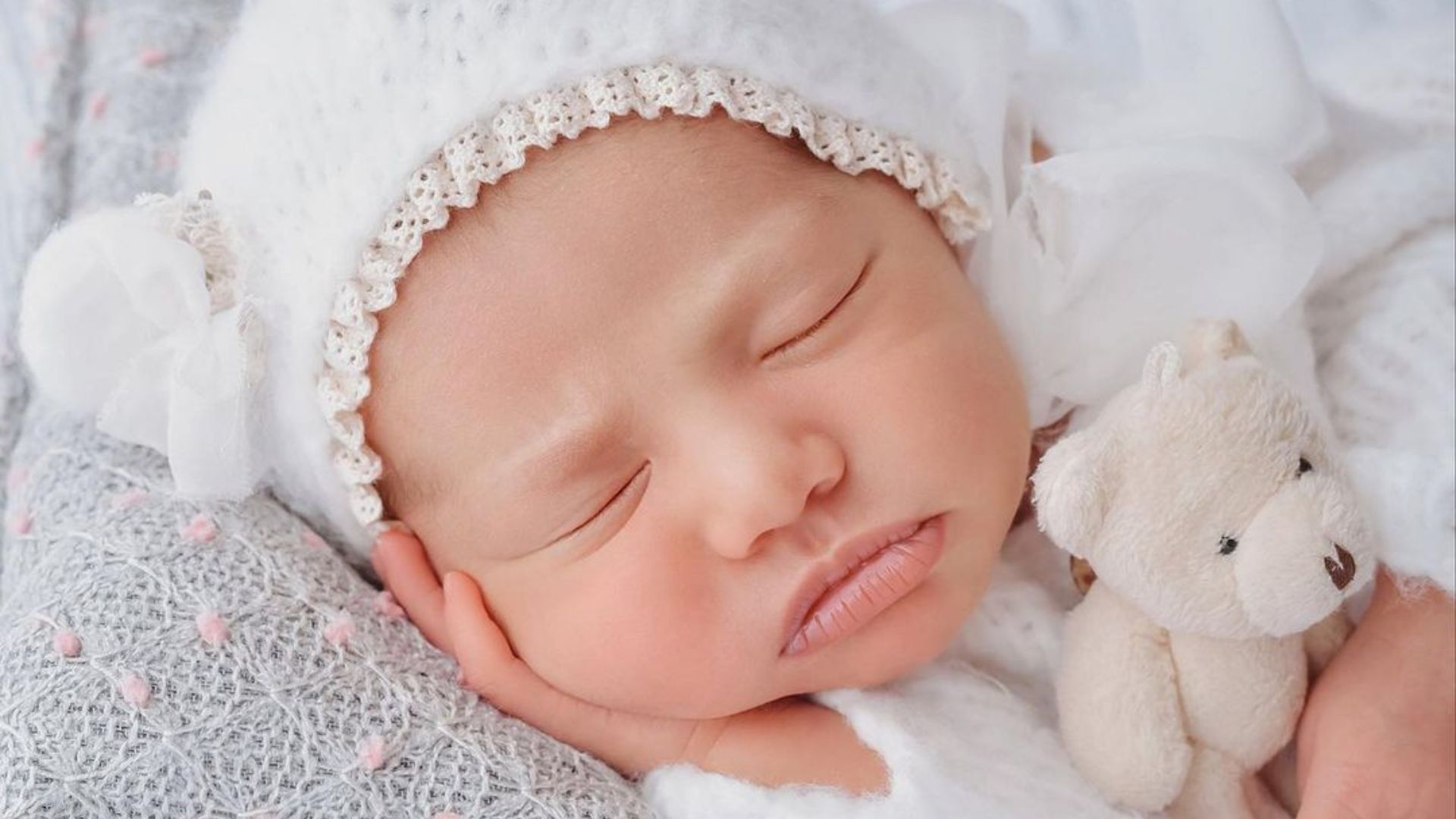 Mavie, filha de Newmar e Bruna Biancardi, dormindo apoiada em m&atilde;o com touca de orelhas e abra&ccedil;ada a urso de pel&uacute;cia, em ensaio 'newborn' fotografado por Ingryd Alves