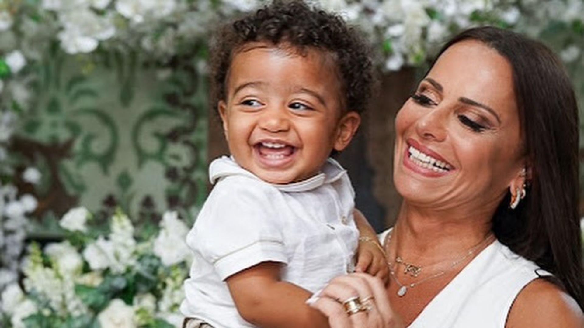 Viviane segurando seu filho no colo