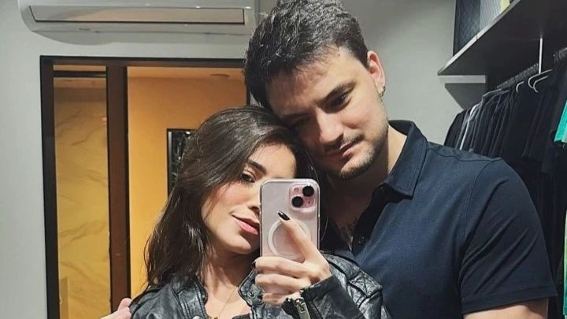 Casal posando para fotos no espelho