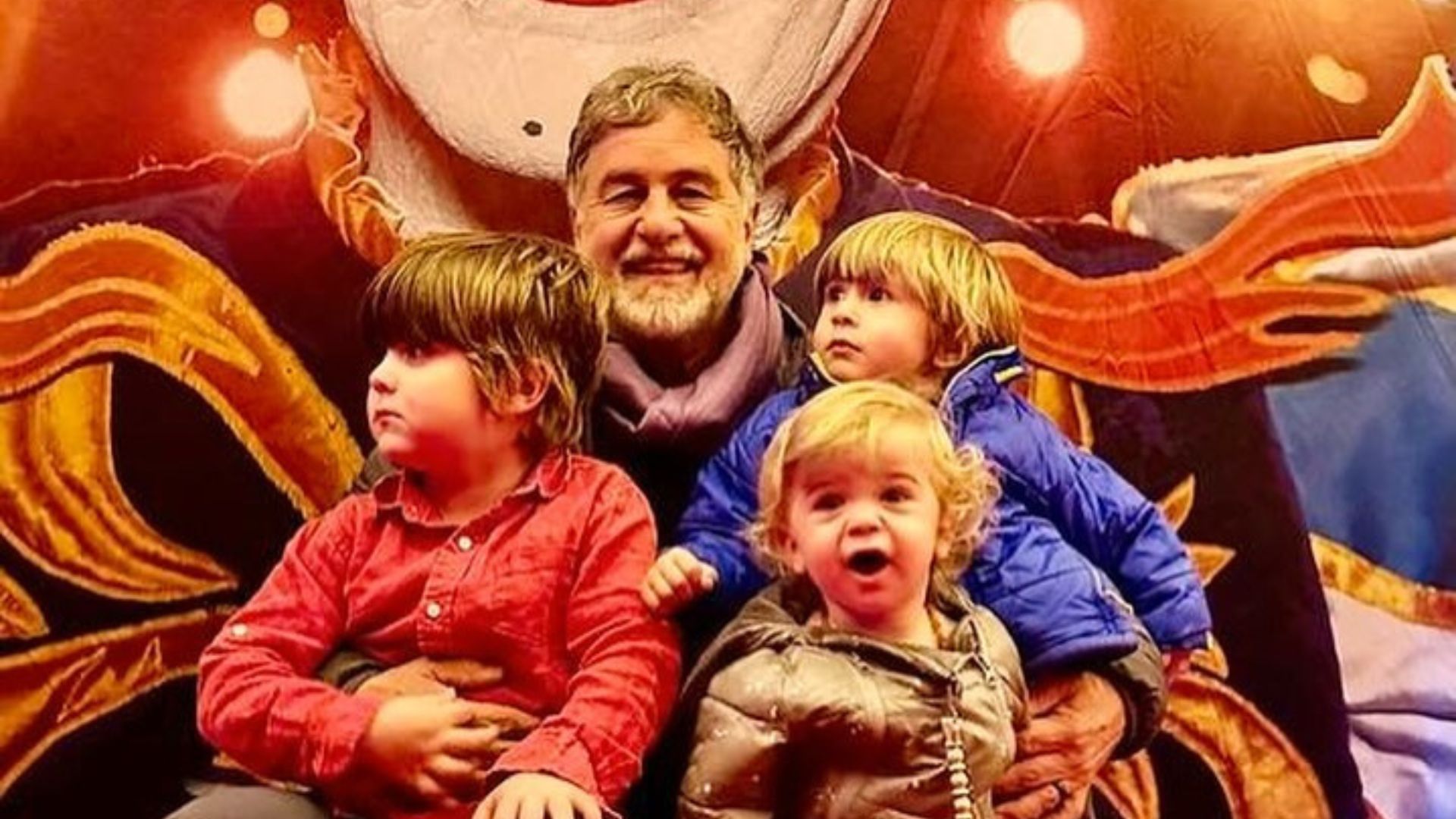 Homem posando para foto com os netos