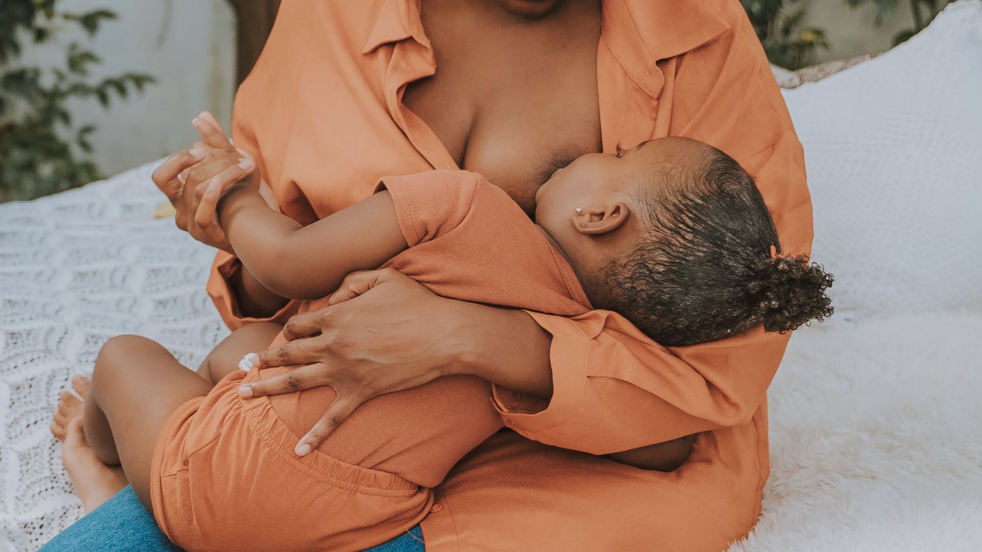 Mulher negra amamentando crian&ccedil;a