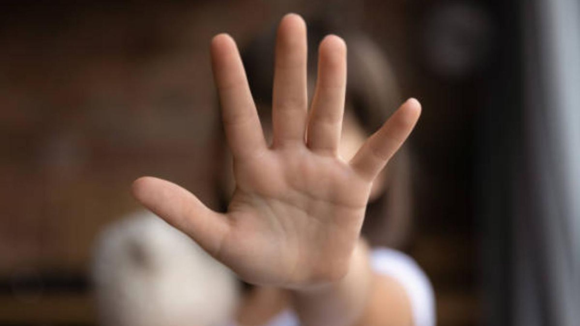 Crian&ccedil;a se protegendo com a m&atilde;o