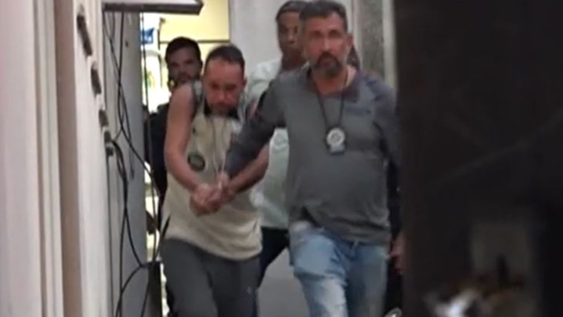 Homem sendo levado para delegacia