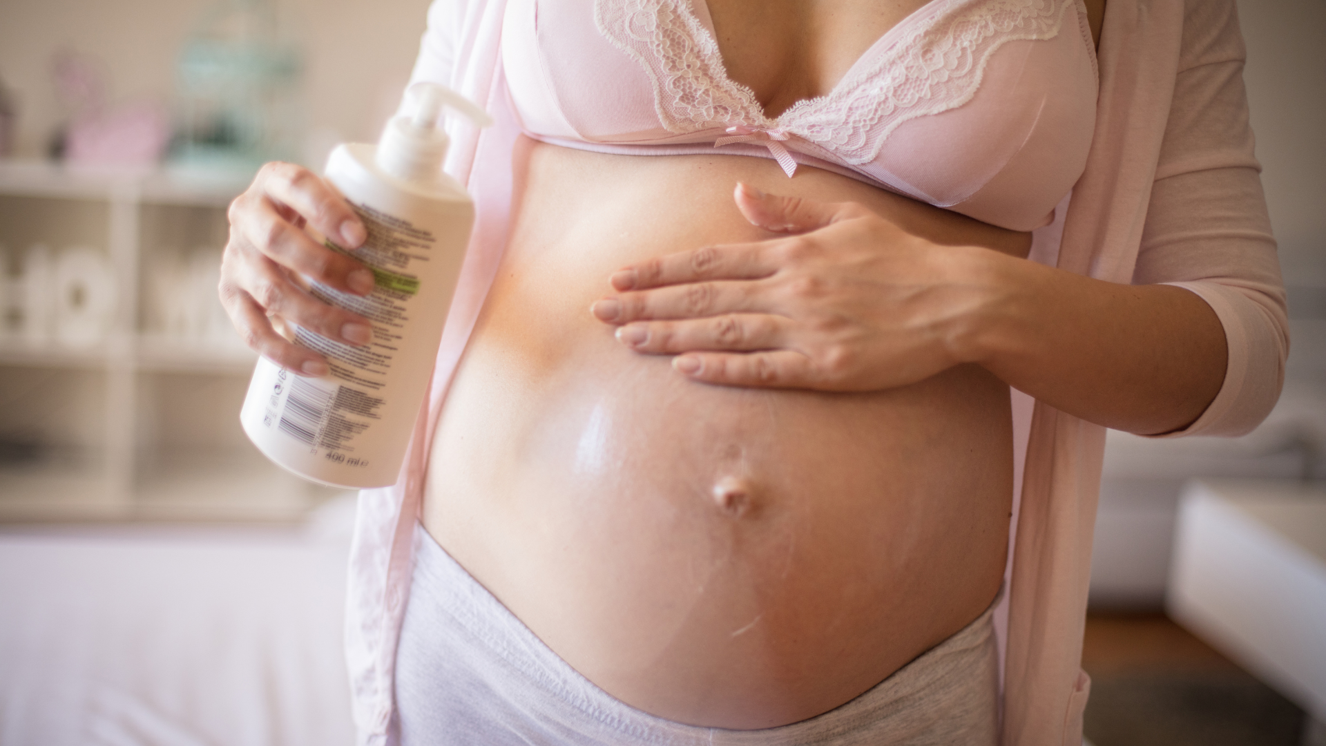 Mulher passando creme na barriga