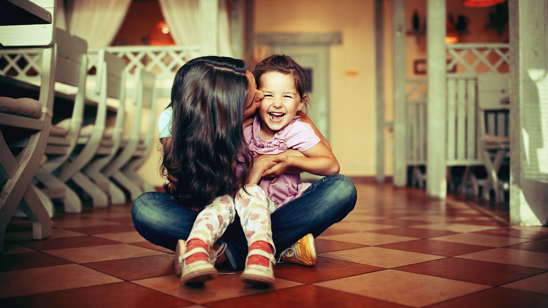 M&atilde;e beijando filha