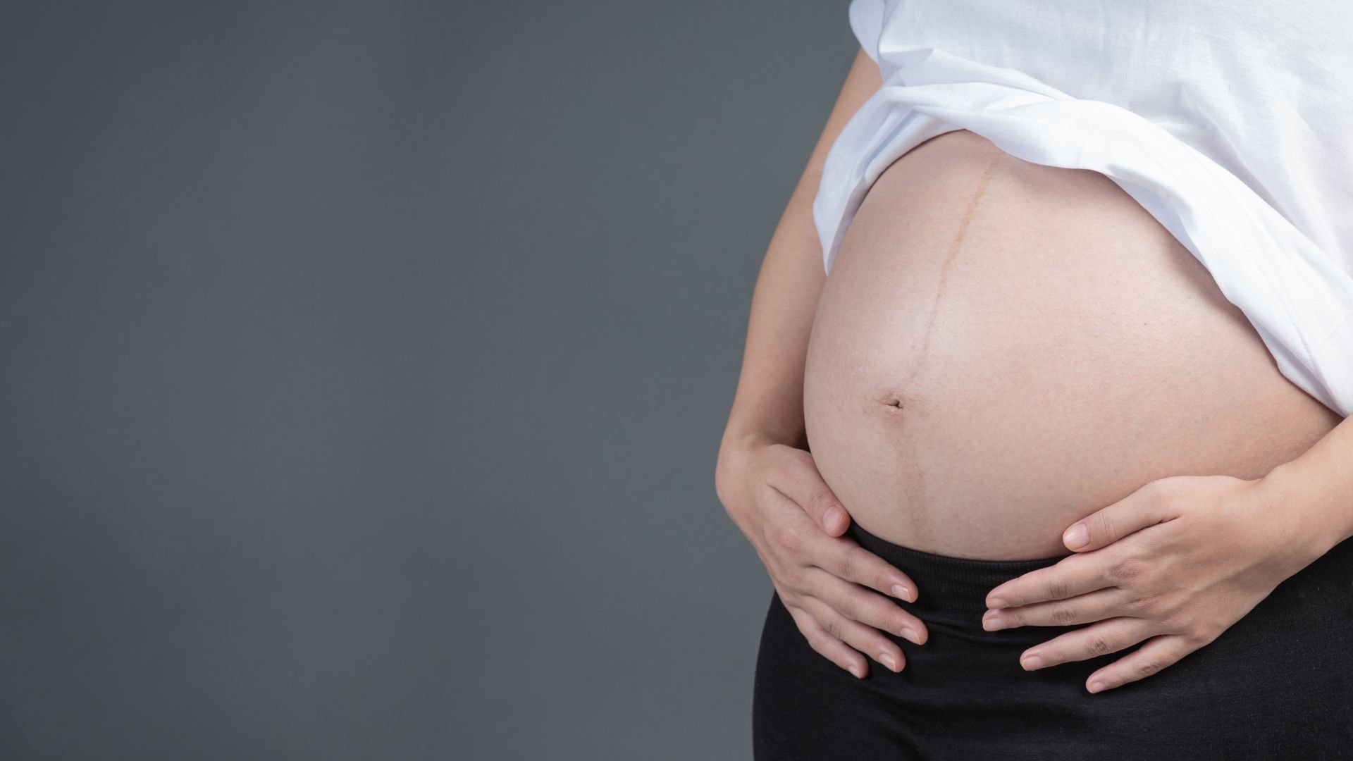 Gr&aacute;vida com a m&atilde;o na barriga