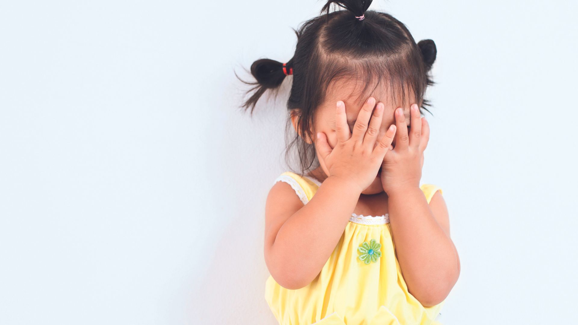 Menina com m&atilde;os no rosto