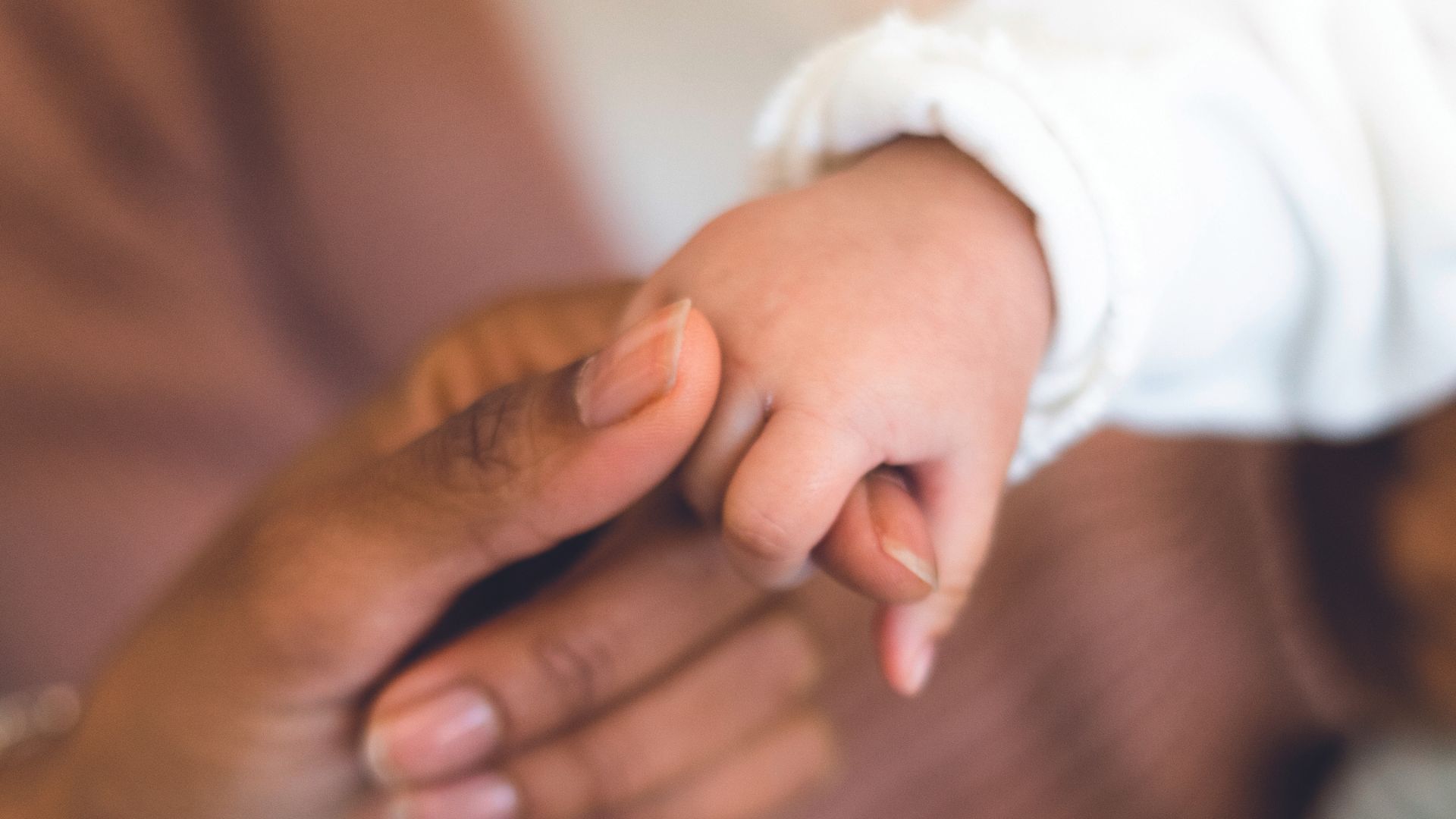 Beb&ecirc; segurando m&atilde;o