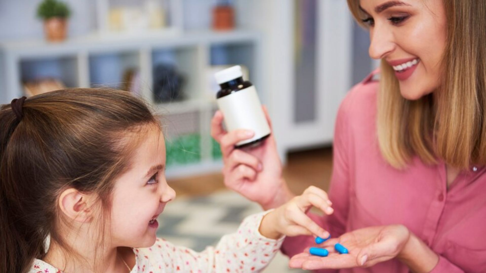 Mulher dando rem&eacute;dio para crian&ccedil;a