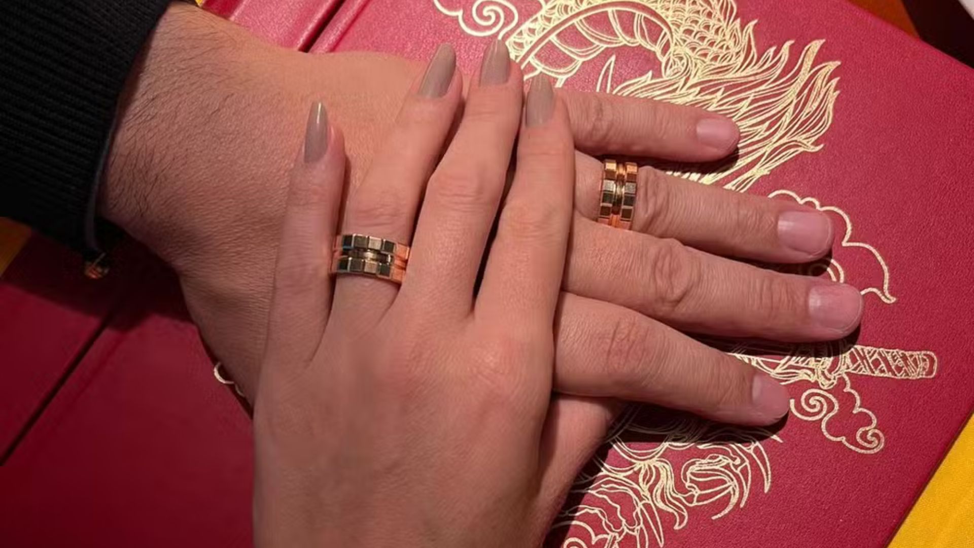 M&atilde;o de casal com alian&ccedil;as de outro