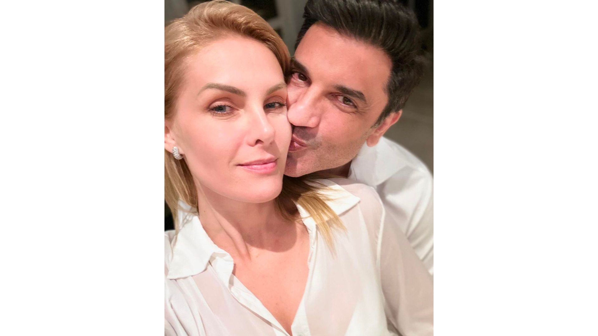 Edu Guedes dando um beijo na bochecha de Ana Hickmann
