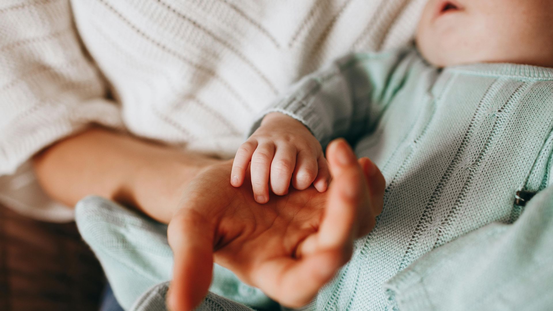 Mulher dando a m&atilde;o para beb&ecirc;