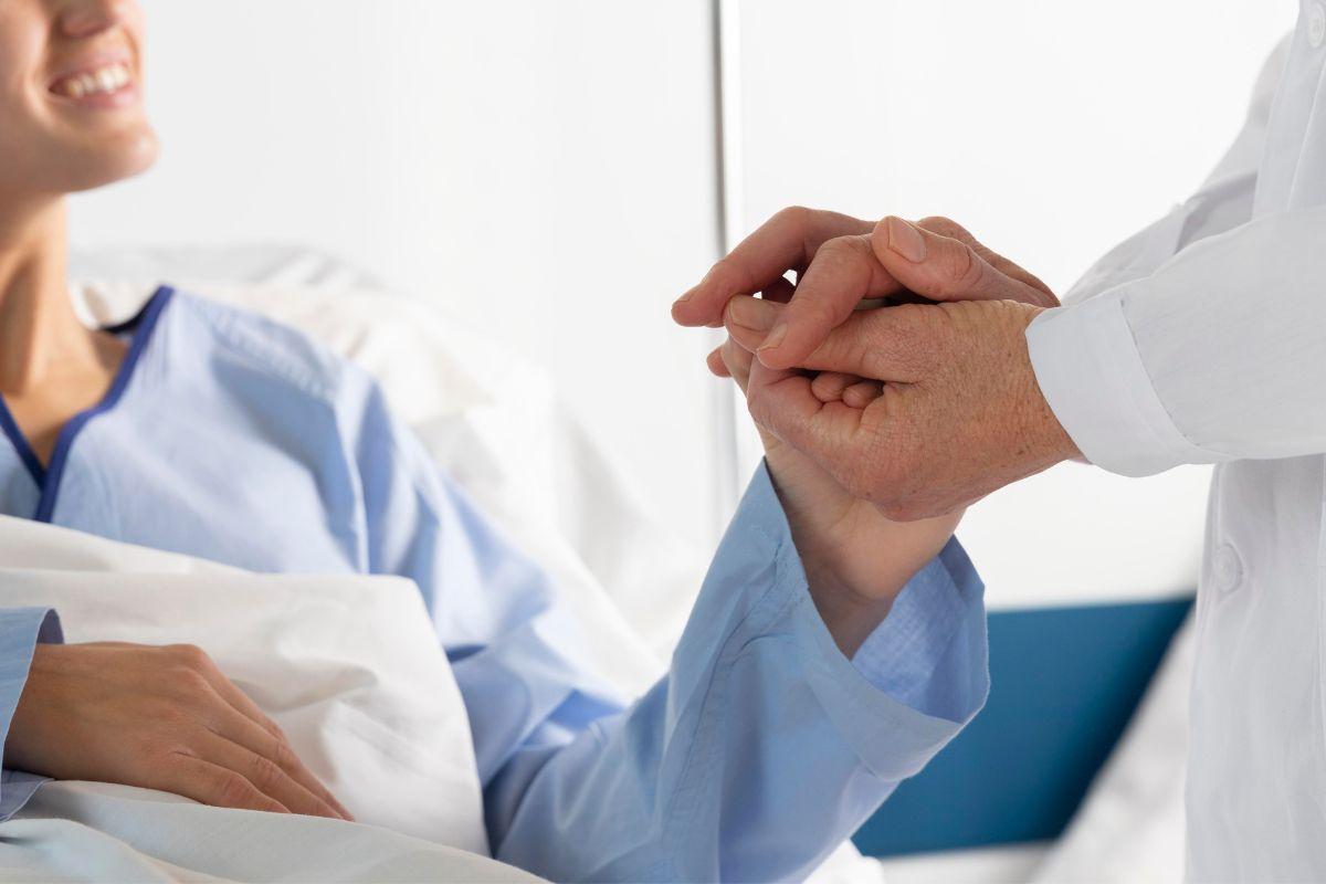 Paciente, médico segurando a mão de paciente, paciente sorrindo para médico