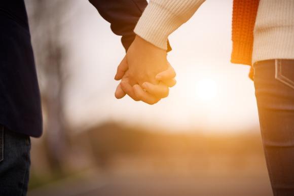 heterosexual-couple-holding-hands-and-walking-together-outdoors-picture-id641357926