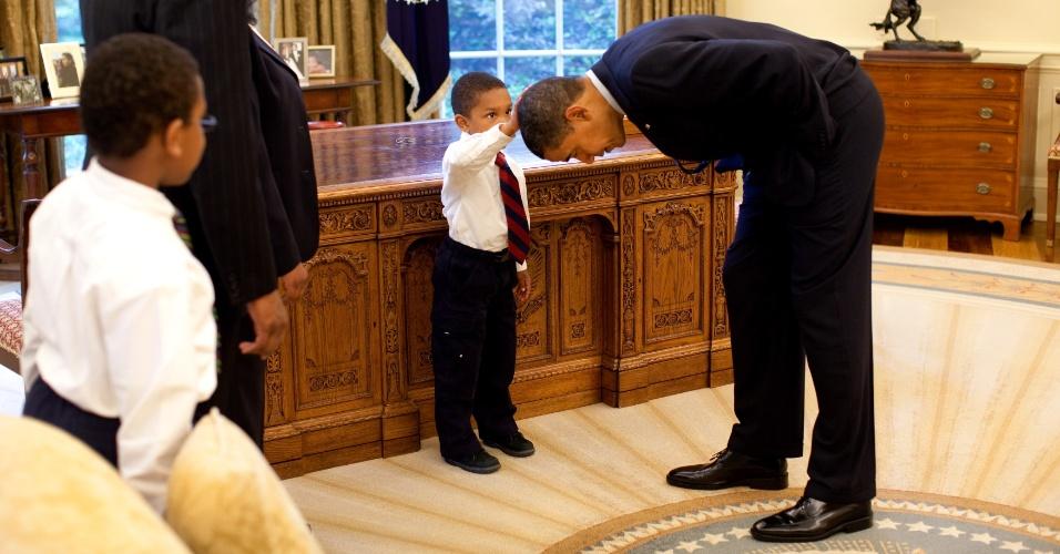 8mai2009---o-presidente-dos-eua-barack-obama-abaixa-a-cabeca-para-que-o-filho-de-um-de-seus-funcionarios-(1)