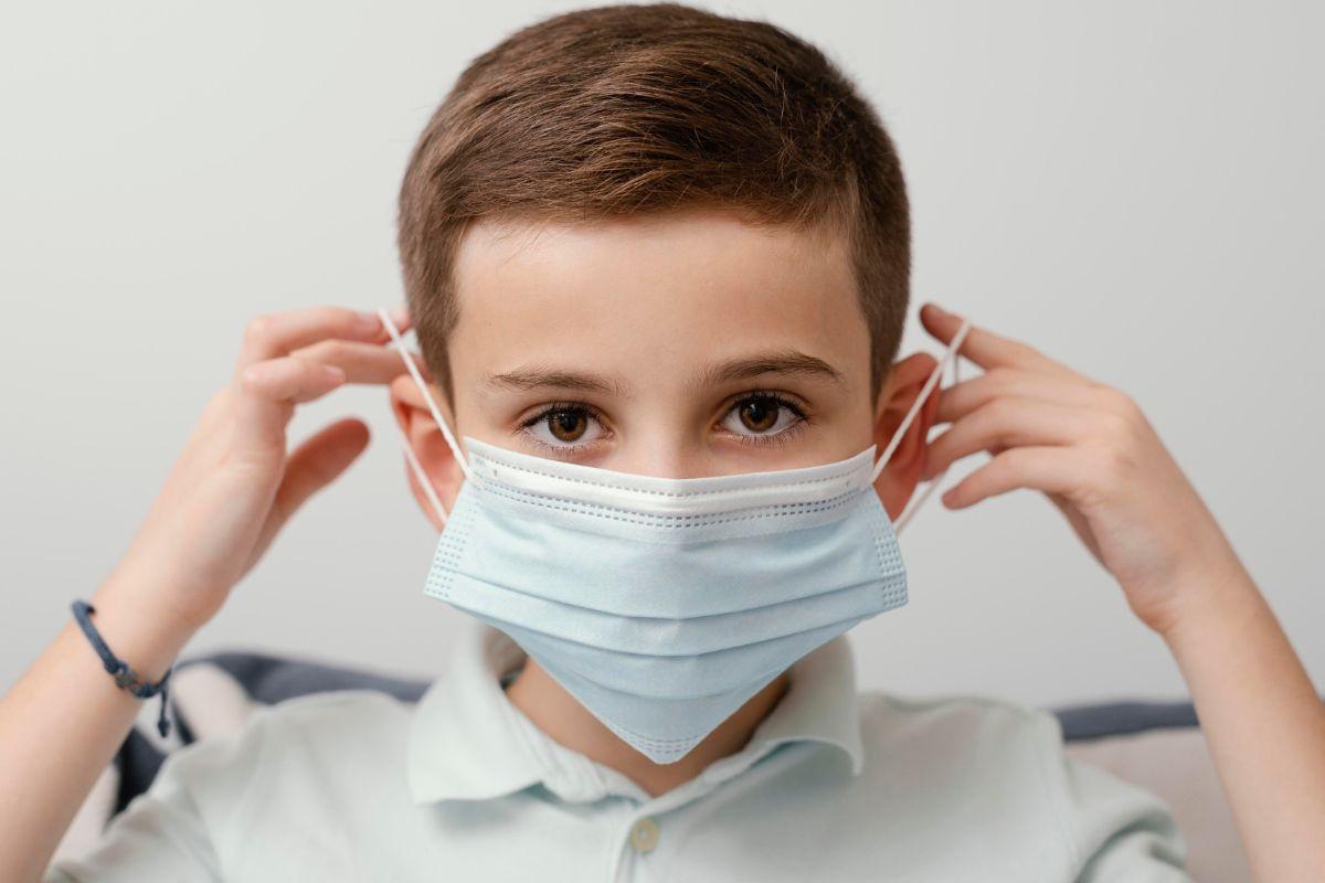 Criança colocando máscara