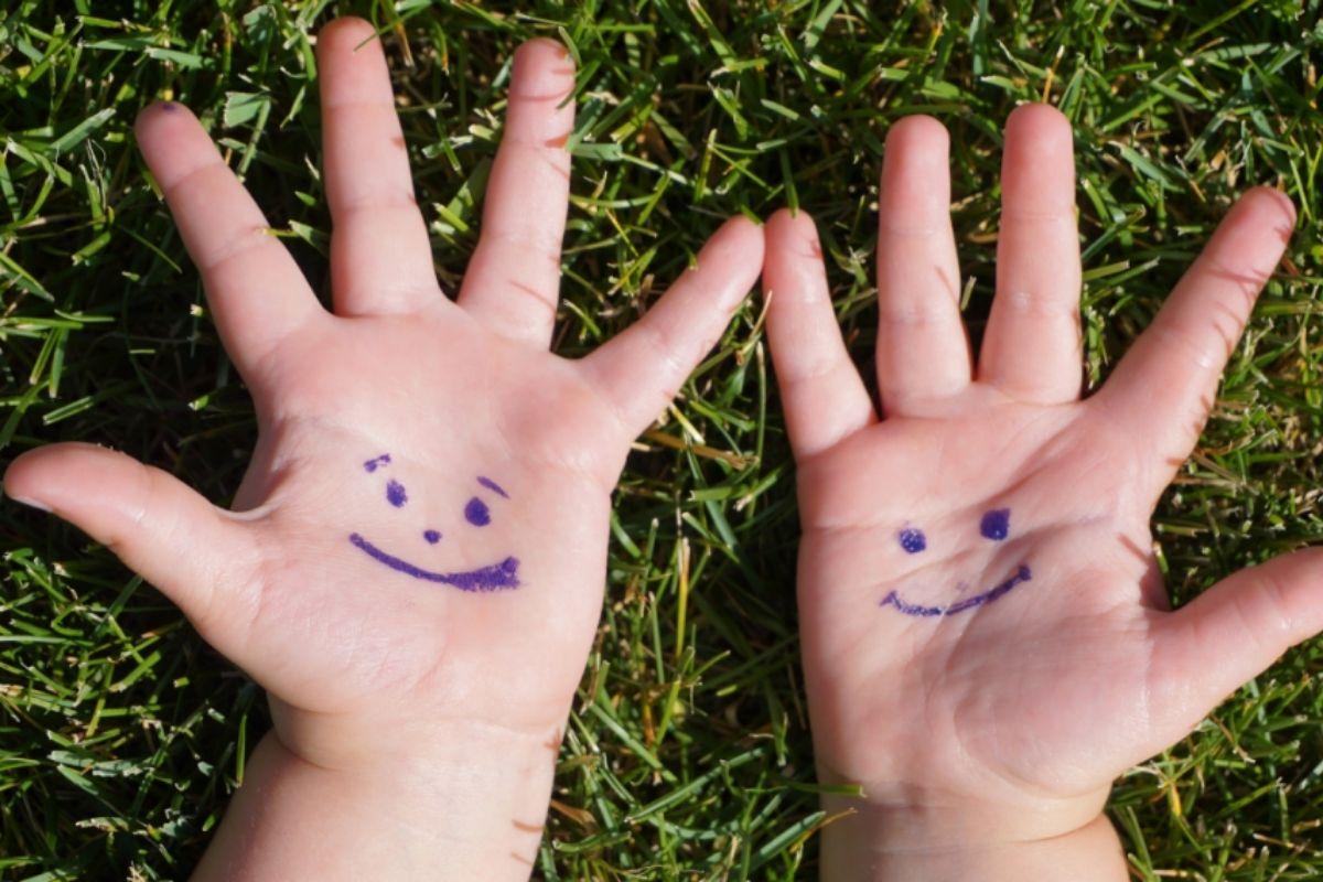 M&atilde;os com sorrisos desenhados