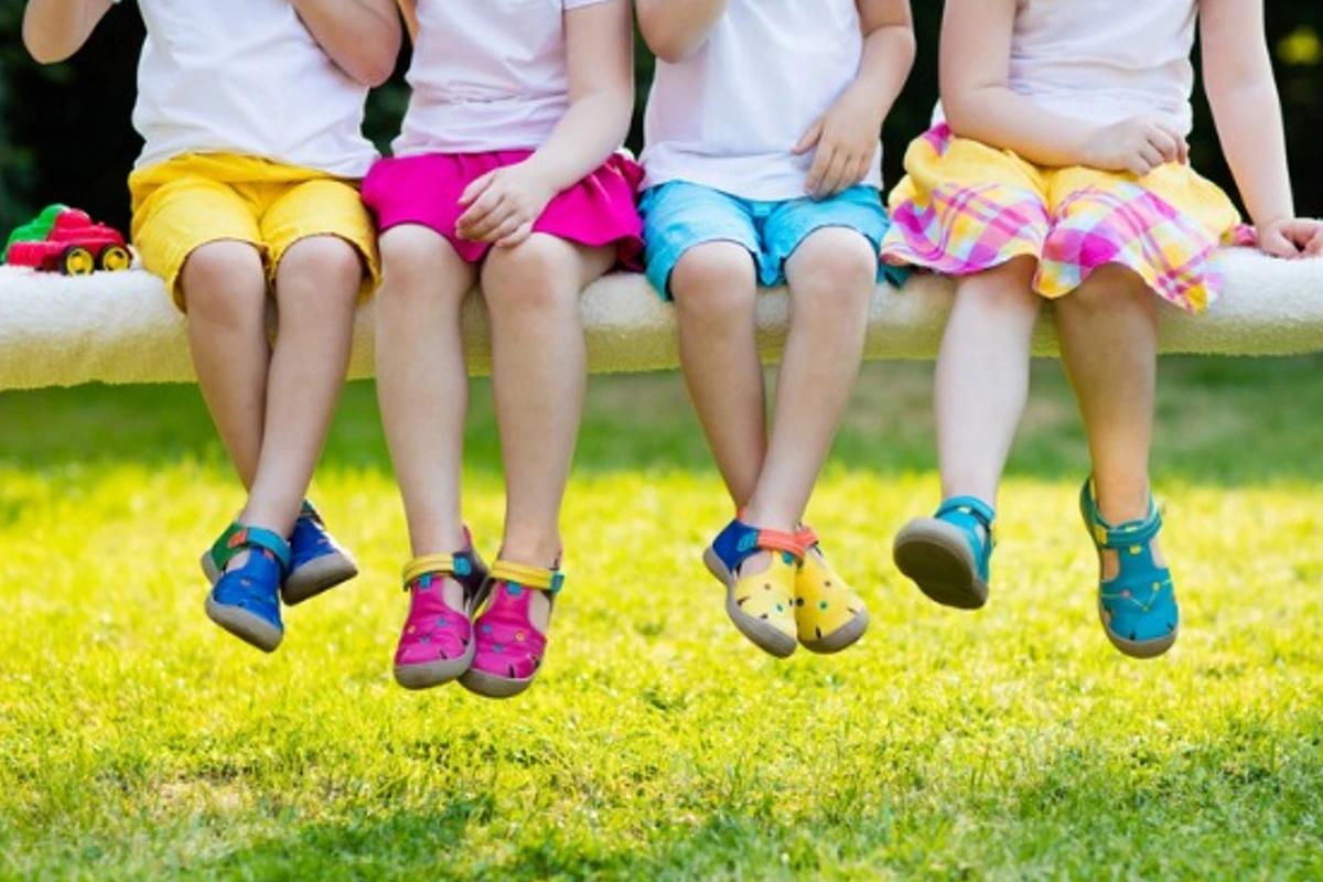 Crianças brincando sentadas em uma árvore