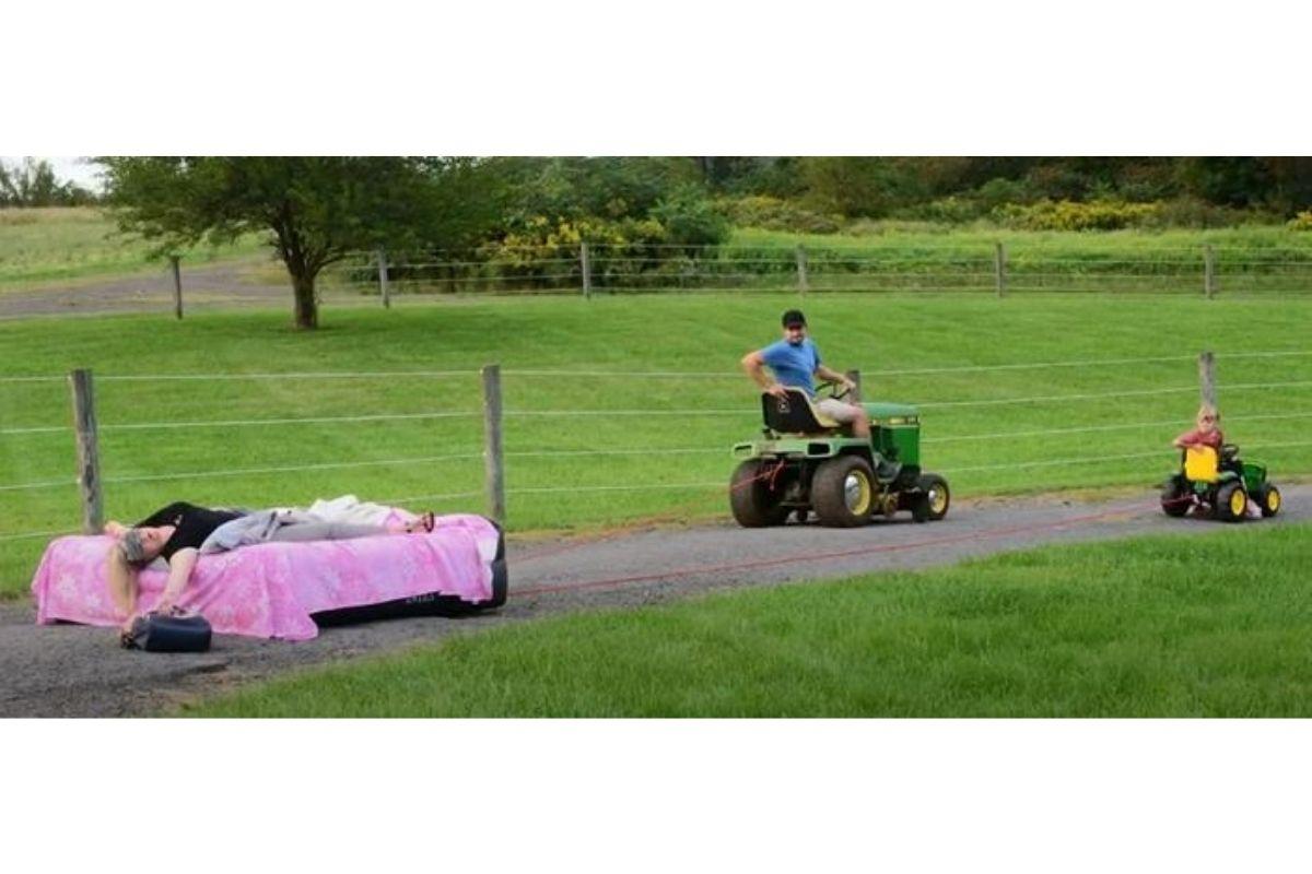 O pai e a filha puxando a mãe deitada utilizando um trato