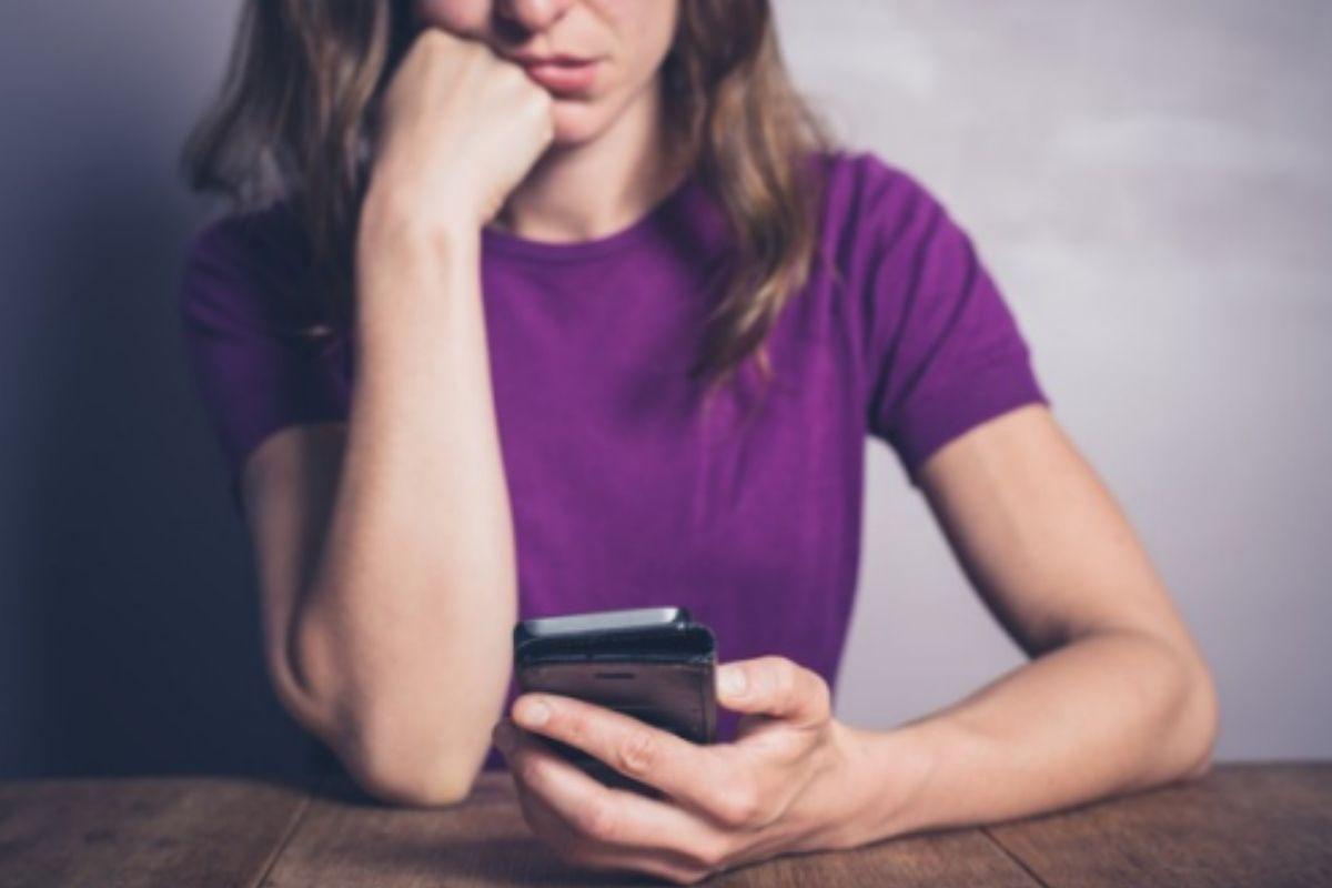 Mulher com celular na mão