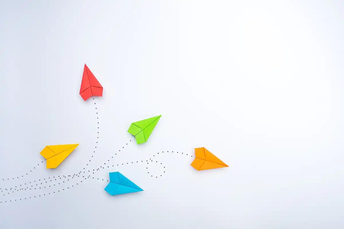 Aviões de papel coloridos indo para diferentes direções